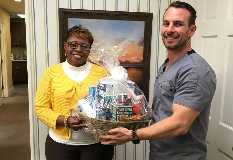 Dentist giving a dental gift basket to patient