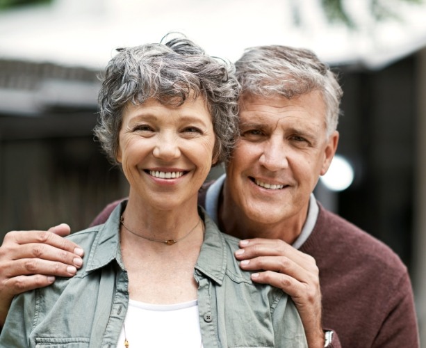 Man and woman smiling after dental restoration