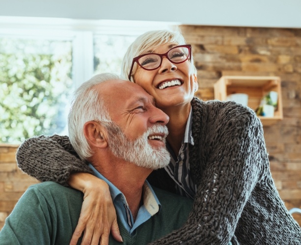 Man and woman with dentures smiling together