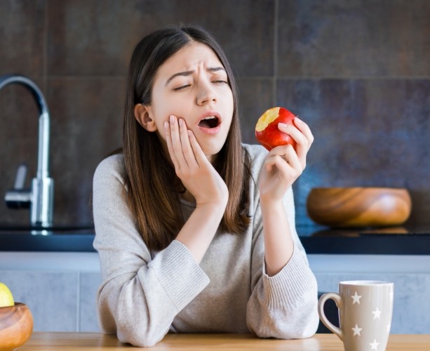 Woman in pain after biting an apple needs emergency dentistry