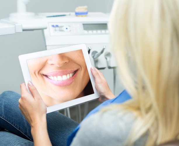 Woman looking at her lab created smile design on computer screen