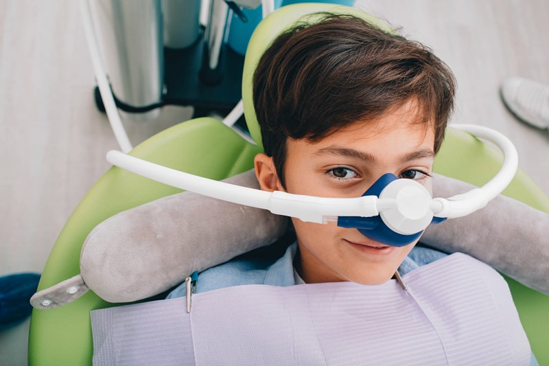 A smiling boy wearing a nose mask for nitrous oxide sedation